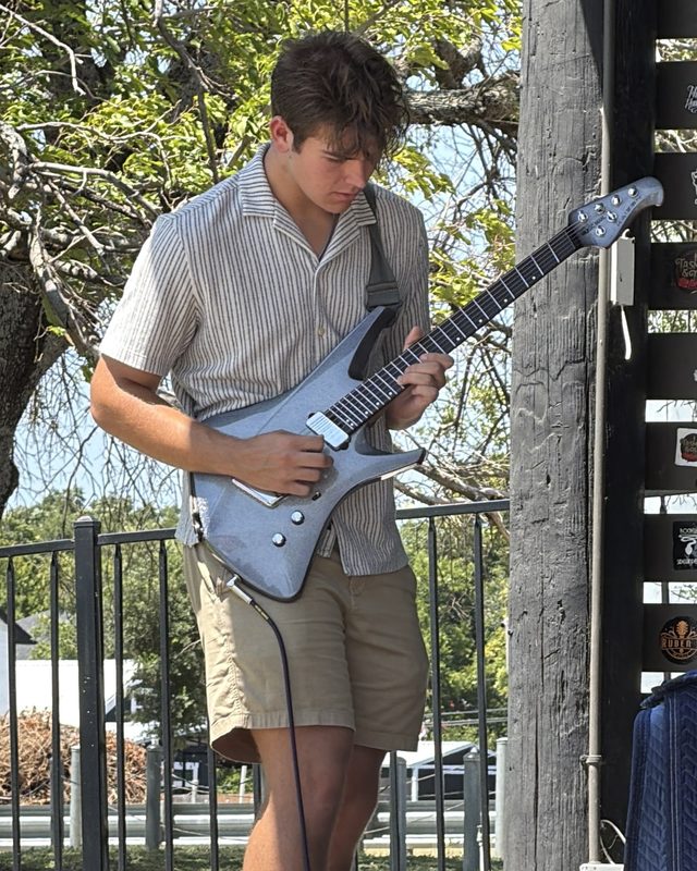 Jackson playing electric guitar on an outdoor stage